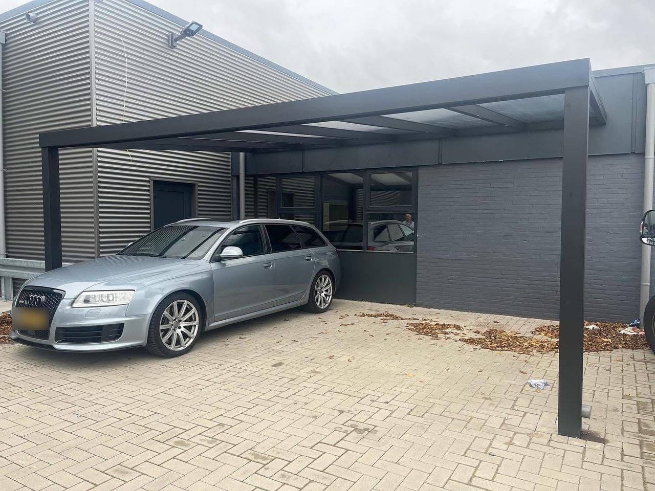 Vrijstaande antraciet aluminium carport met een auto eronder