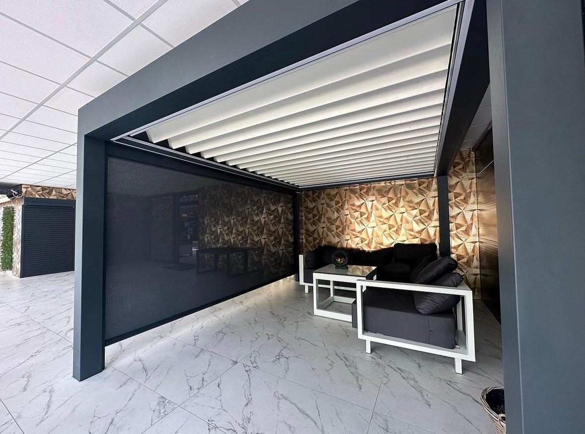 Lamellendak met screen en loungeset in een showroomopstelling