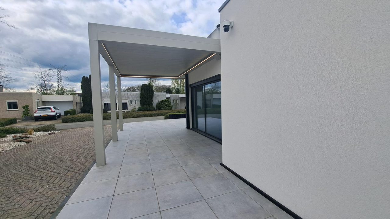 Overkapping met witte aluminium profielen aan een witte moderne woning