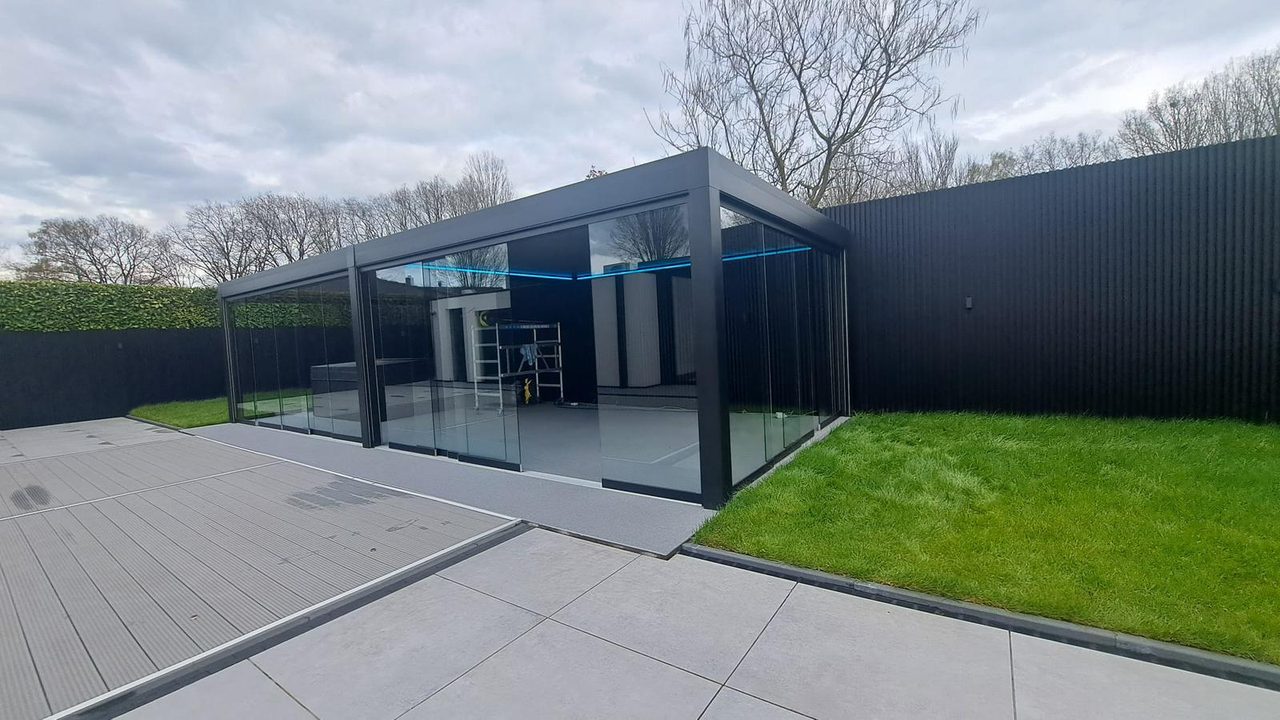 Vrijstaande tuinkamer met glazen schuifwanden en sfeerverlichting