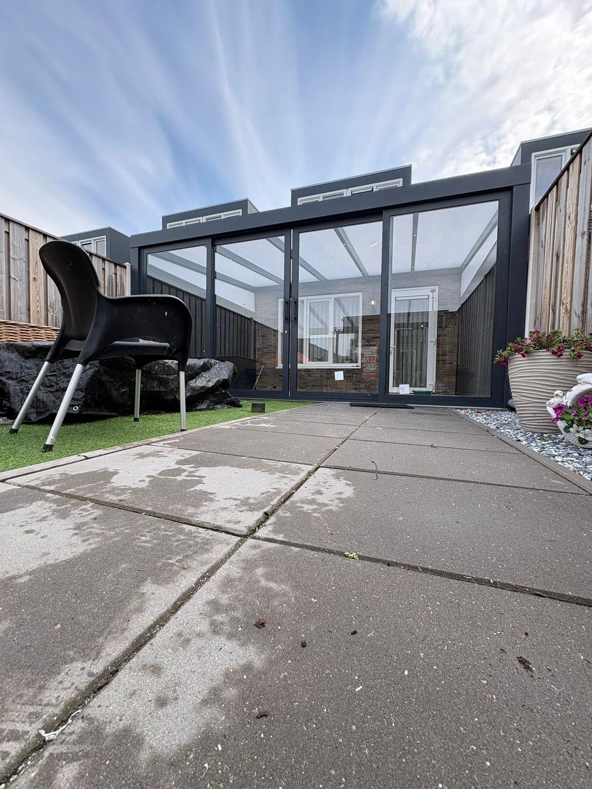 Tuinkamer aan het eind van een tuinpad onder een wolkenlucht