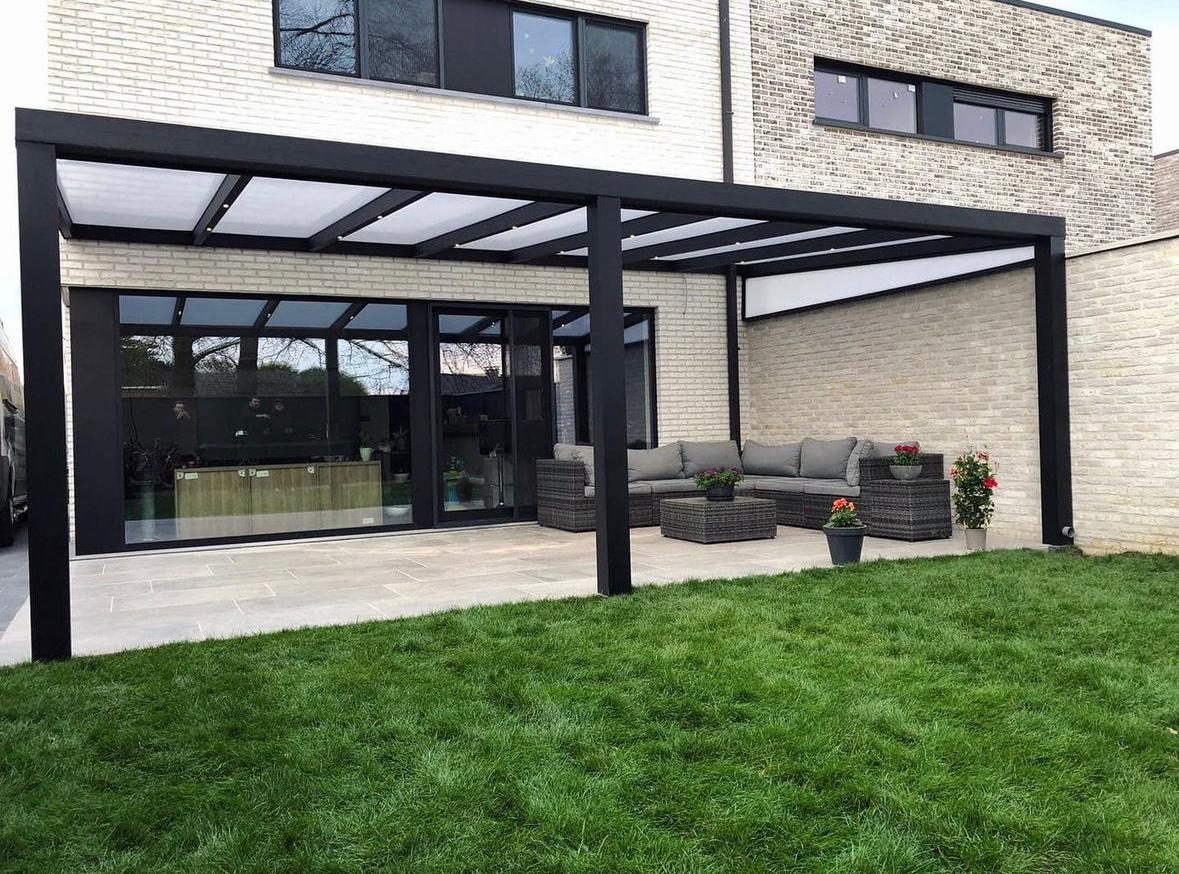 Terrasoverkapping met opaal dak boven een loungeset aan een lichte bakstenen woning